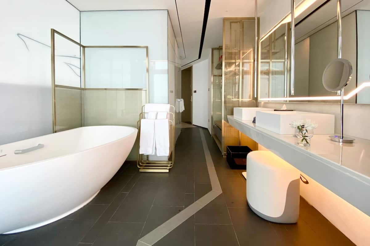 A modern bathroom with a large bathtub, a glass shower enclosure, and a vanity with a mirror.