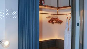 A modern bathroom with a built-in bench, a glass shower enclosure, and a hanging robe rack.