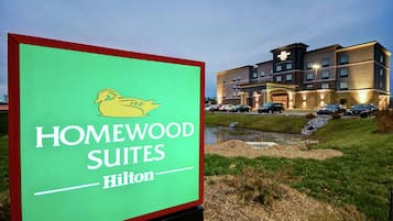Señal de Homewood Suites by Hilton con un edificio moderno al fondo.