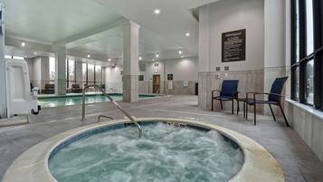 Uma área de spa com hidromassagem, espaço para sentar e piscina.