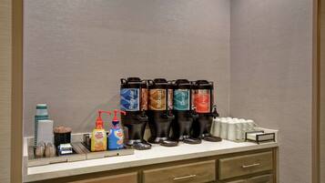 A coffee station with multiple dispensers, coffee cups, and condiments.
