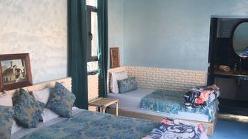 Un dormitorio con dos camas, un espejo grande y una ventana con cortinas.