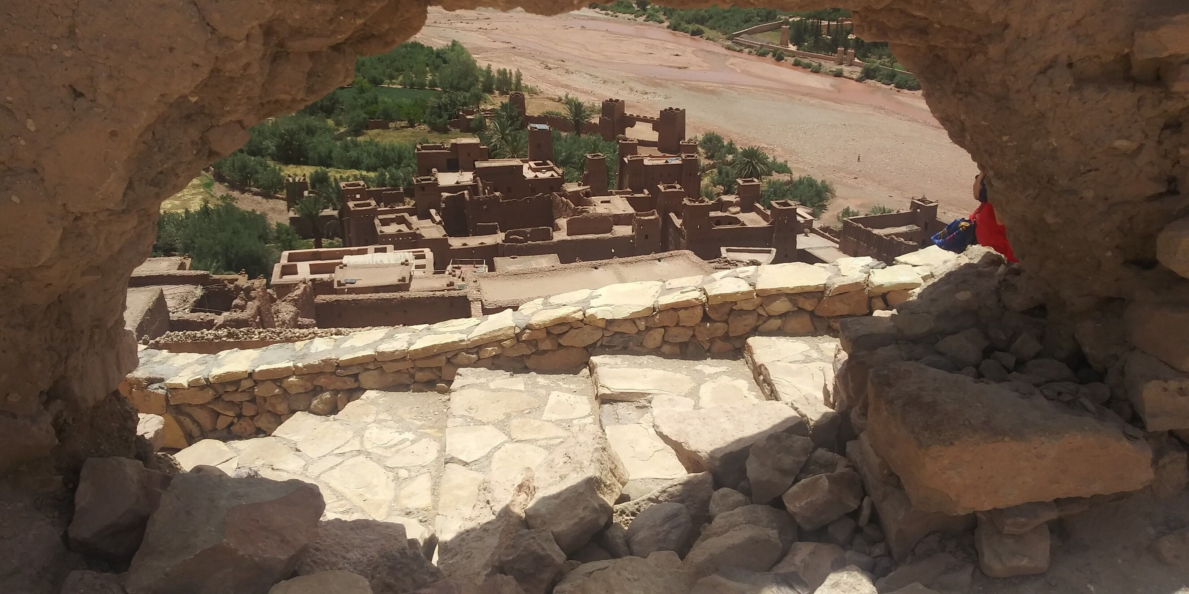 An ancient stone wall with ruins in the background.