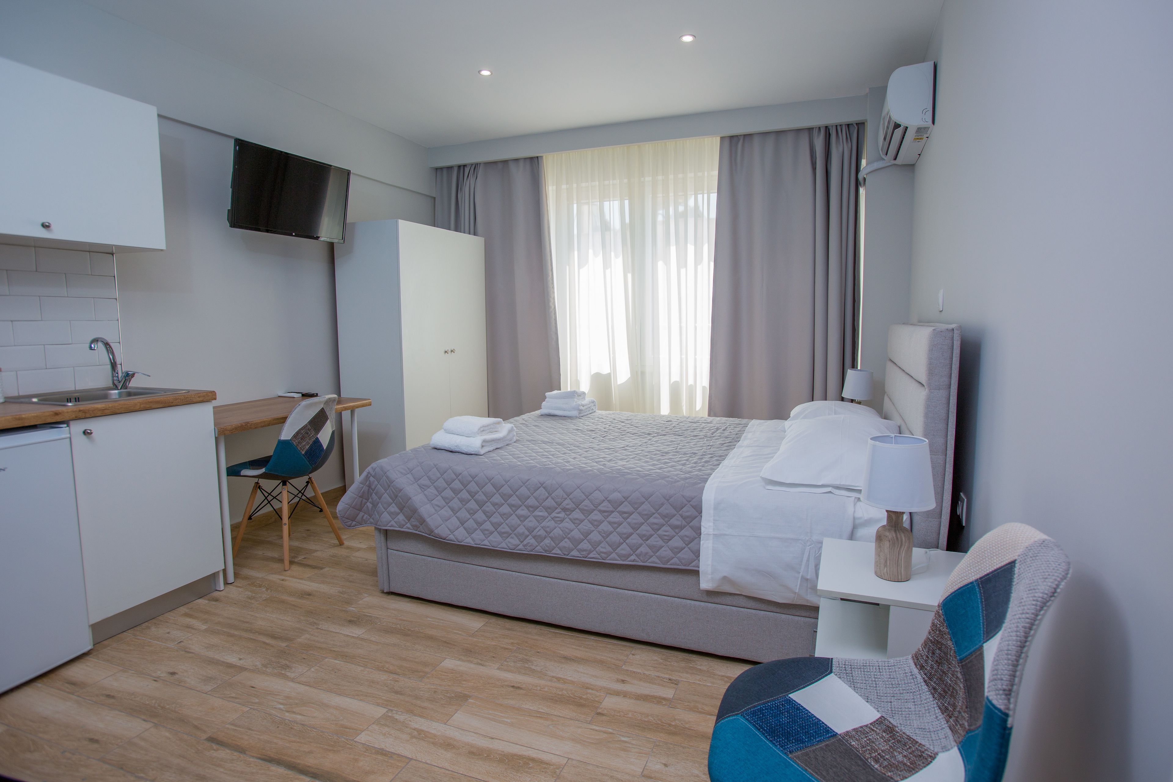 Une chambre d’hôtel moderne équipée d’un lit, d’un bureau, d’une chaise, d’une télévision et d’une salle de bain.