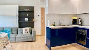 A compact kitchen with a built-in oven, a sink, and a microwave. - Roggia Apartments (Lugano)