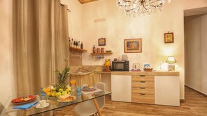 A modern kitchen with a glass dining table, wooden cabinets, and a chandelier. - Bella Palermo (Palermo)