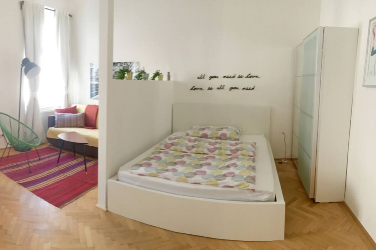 Una habitación pequeña con cama, escritorio y silla.