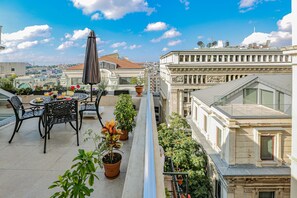 A rooftop terrace with a table, chairs, potted plants, and a view of the cityscape. - No 8 Galata (Istanbul)
