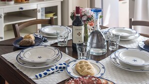 Mesa posta com pratos, copos, garrafa e alimentos.