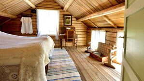A cozy attic bedroom with a wooden ceiling, a bed with a white blanket, a wooden chair, and a small table with a checkered tablecloth. - Thon Hotel Sortland (Sortland)