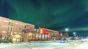 A hotel with a red sign, a visible entrance, and a parking area. - Thon Hotel Sortland (Sortland)