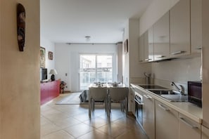 Eine moderne Küche mit Essbereich, großen Fenstern und Blick ins Freie.