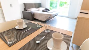 A dining area with a table set for two, including cups, glasses, and cutlery. - Prestige Du Lac Apartments (Lugano)