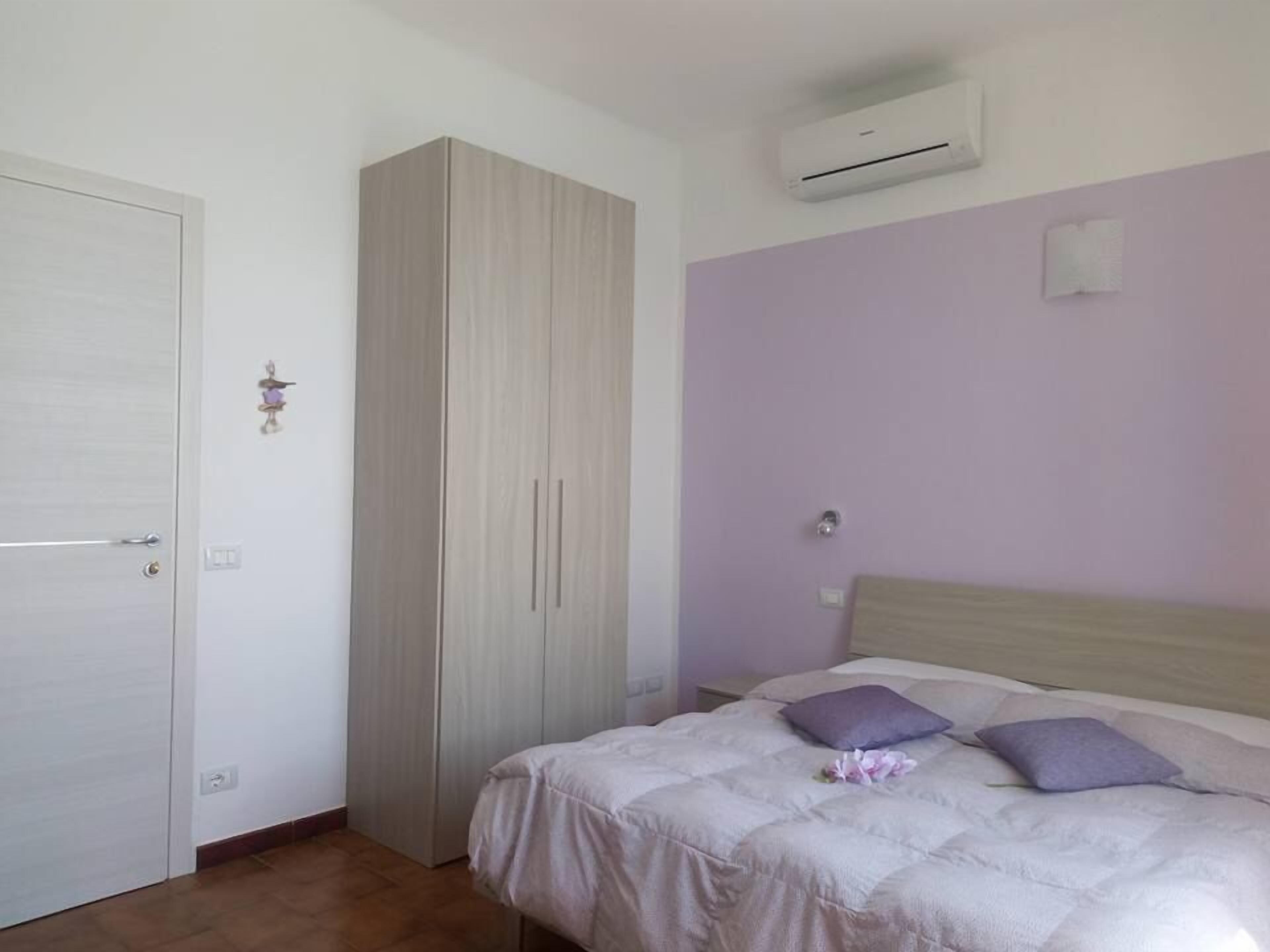 Ein Schlafzimmer mit Bett, Kleiderschrank und Klimaanlage.