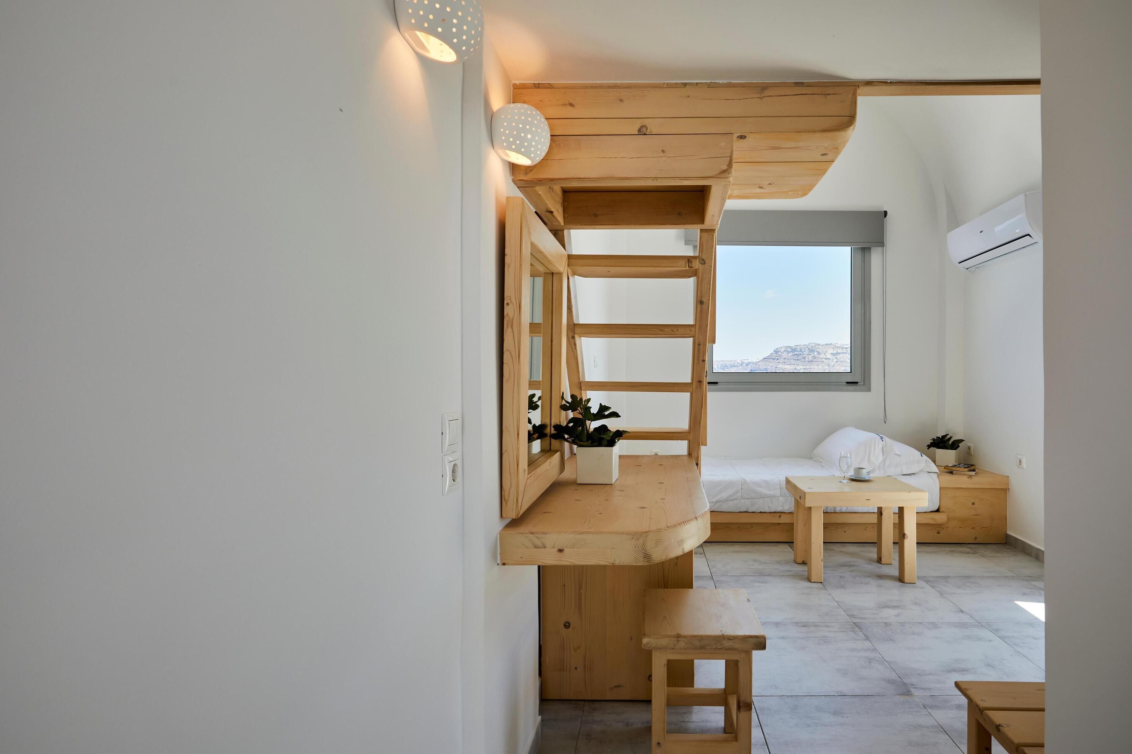 A compact room with a bunk bed, a small desk, and a window with a view.