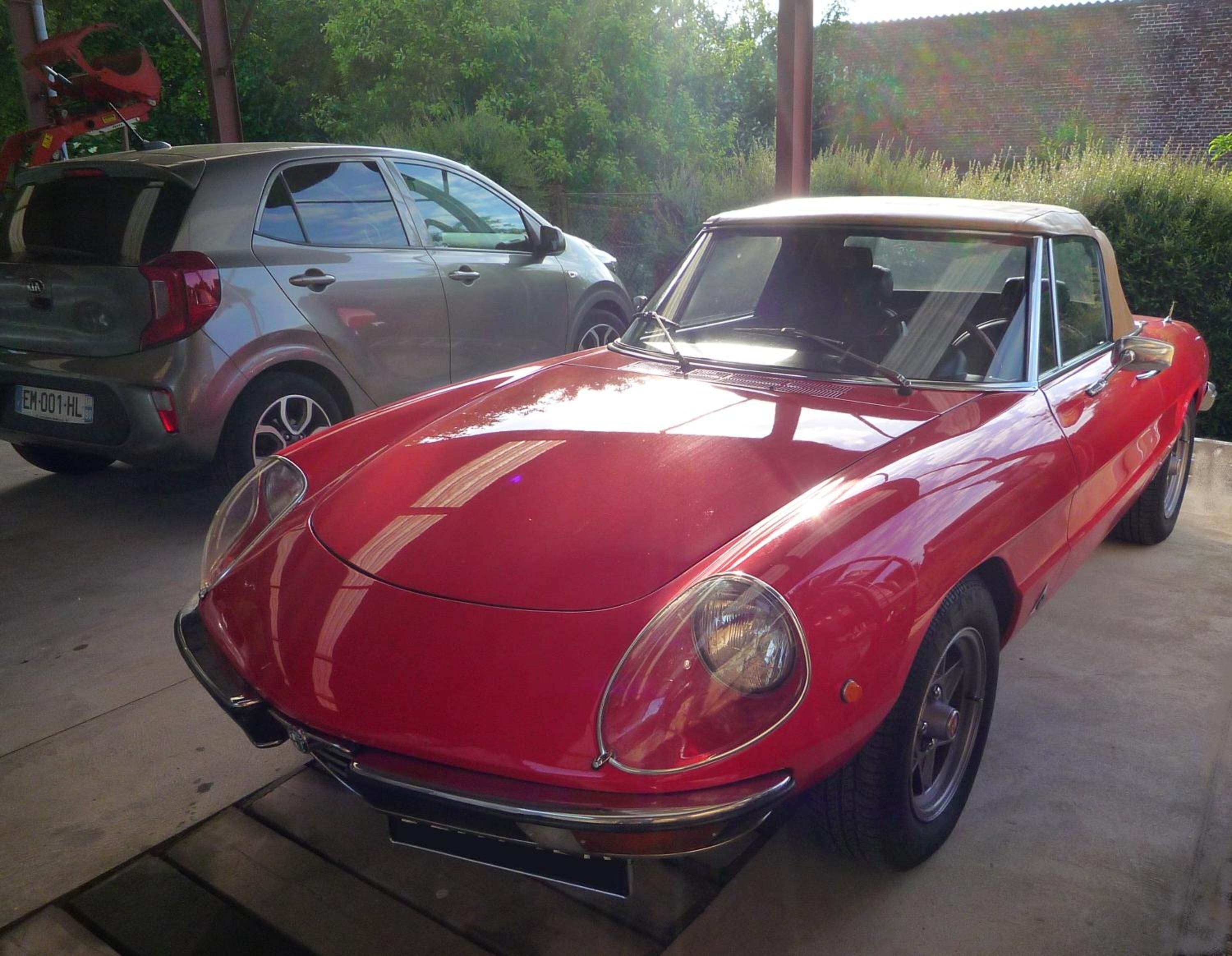 A red convertible car parked in a garage.