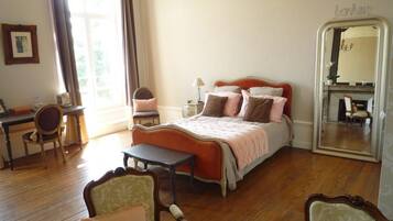 Ein Schlafzimmer mit Bett, Schreibtisch, Stuhl und Spiegel.
