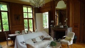 A cozy room with a sofa, chairs, a fireplace, and large windows. - Le Chateau de Plessier-Rozainvillers (Le Plessier-Rozainvillers)