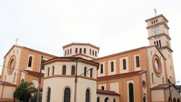 Una iglesia con torre de reloj, ventanas de arco y campanario.