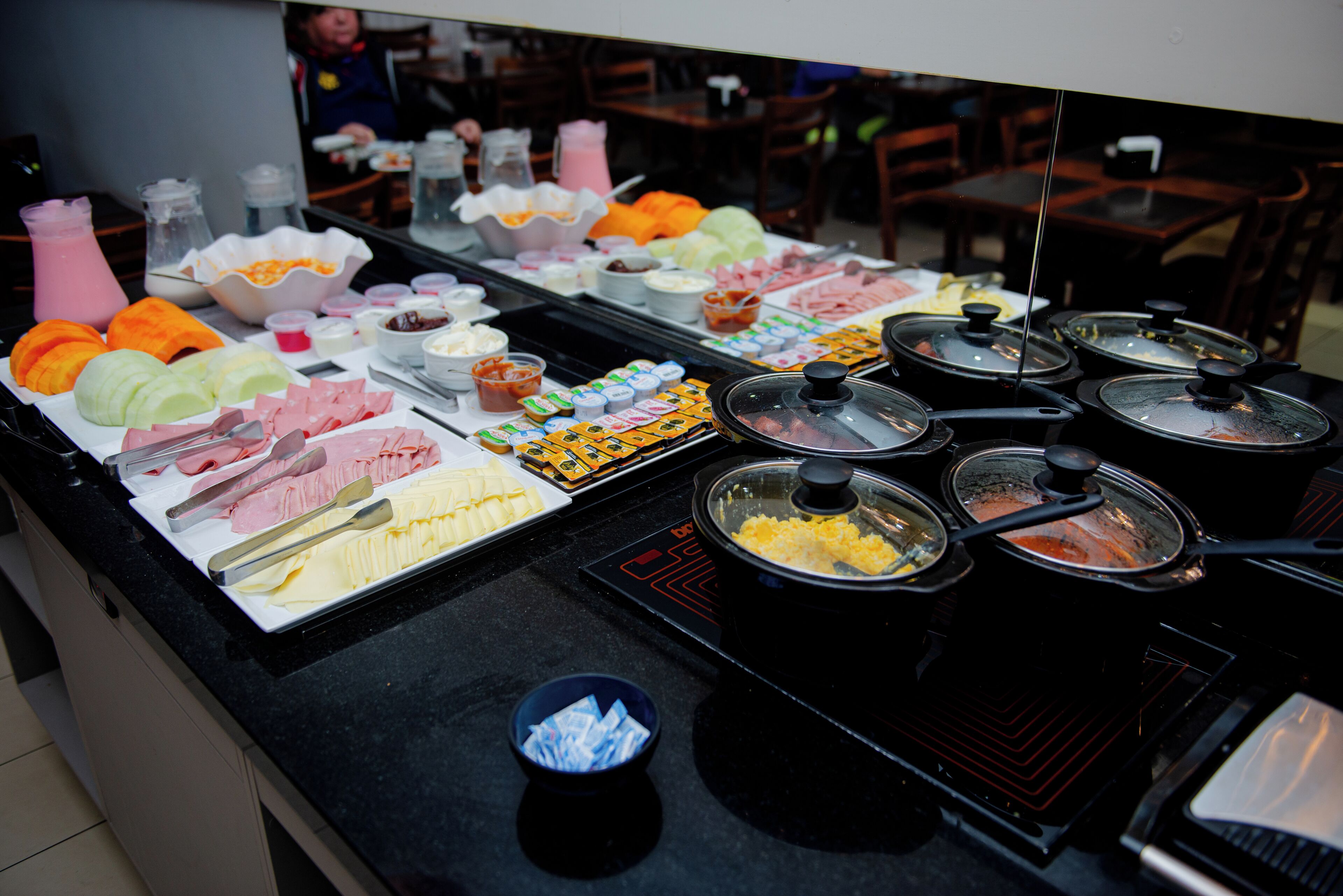 Um buffet com diversos pratos e acompanhamentos.