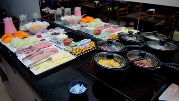 Um buffet com diversos pratos e acompanhamentos.