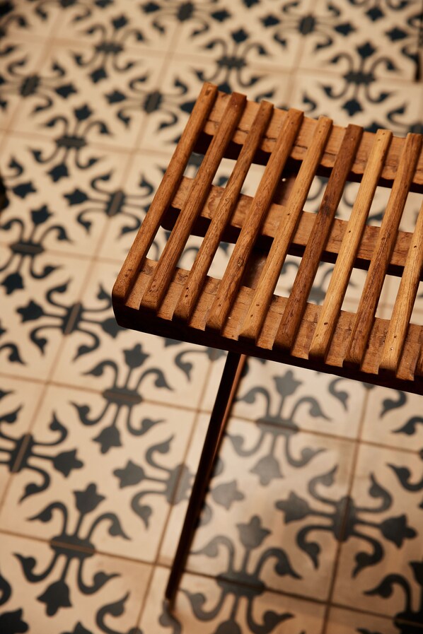 A wooden bench with a slatted design on a tiled floor with a floral pattern. - Relais Castello di Morcote (Vico Morcote)