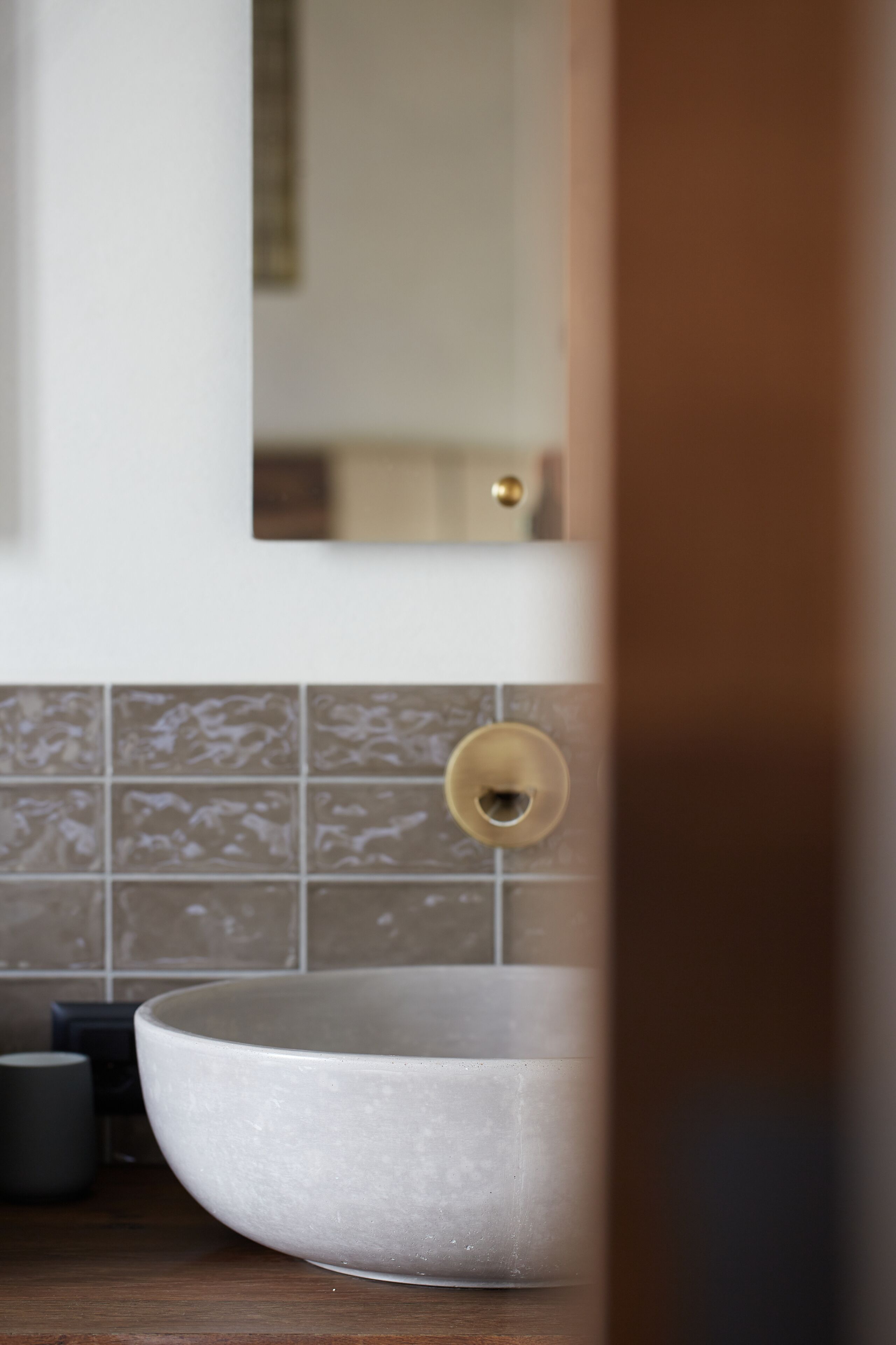 Een badkamer met een groot wit wastafel, een spiegel en een handdoekhouder.