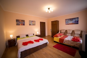 A bedroom with two beds, wooden flooring, and artwork on the walls. - Best Apartments on Kyryla & Mefodia (Mukachevo)