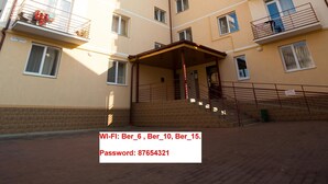 A multi-story building with balconies, a covered entrance, and a brick ground floor. - Best Apartment in the Center (Mukachevo)