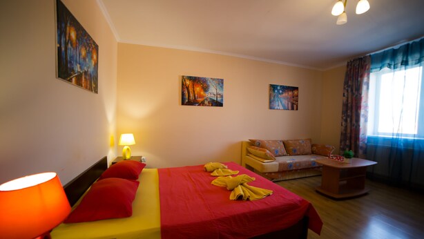 A hotel room with a bed, a sofa, a table, and artwork on the walls. - Best Apartment in the Center (Mukachevo)