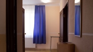 A hallway with a radiator, a blue curtain, a mirror, and a wooden cabinet. - Best Apartment in the Center (Mukachevo)