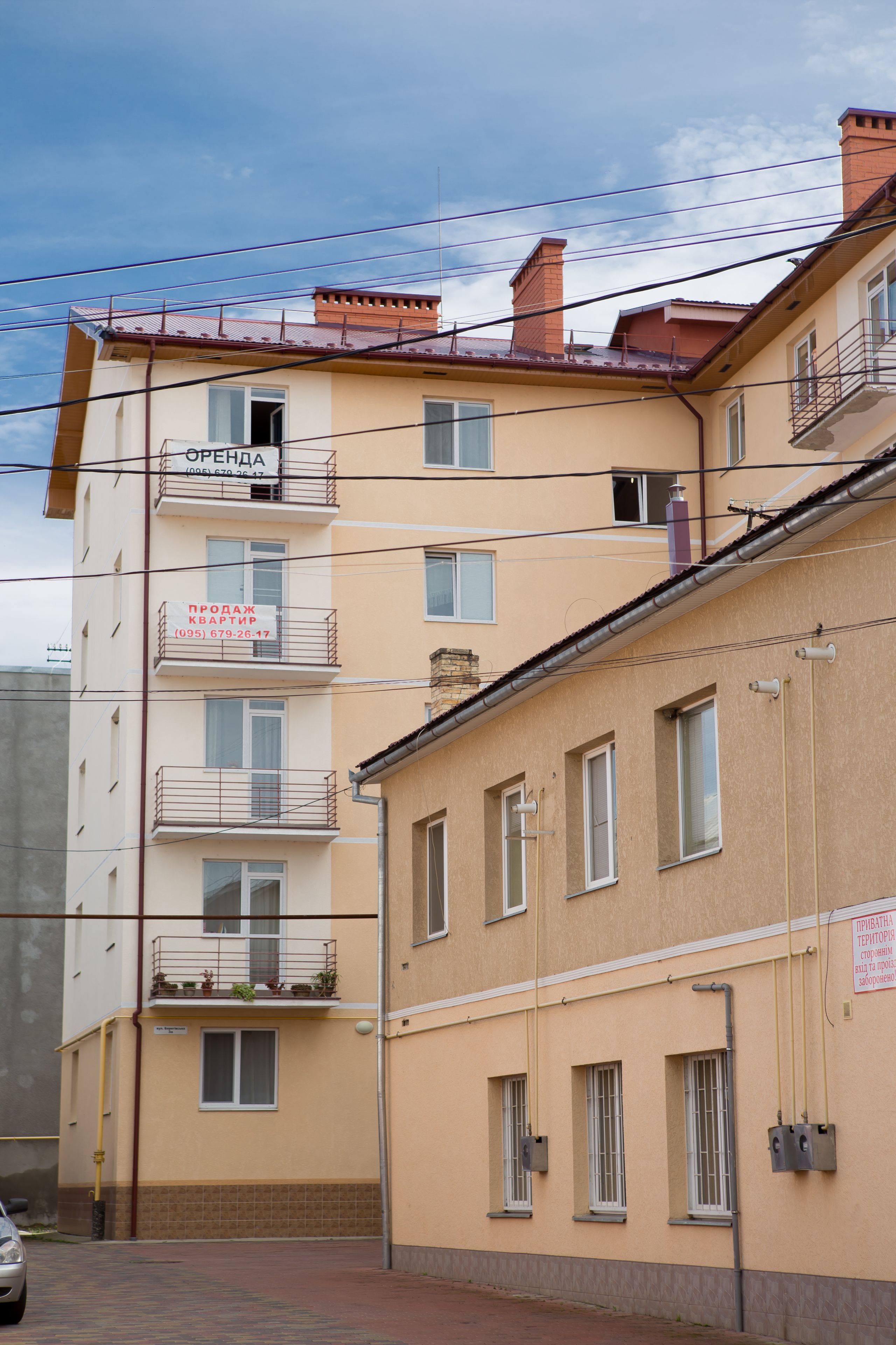 Un immeuble à plusieurs étages doté de balcons, de fenêtres et d’une enseigne bien visible indiquant qu’il s’agit d’un bureau de vente.