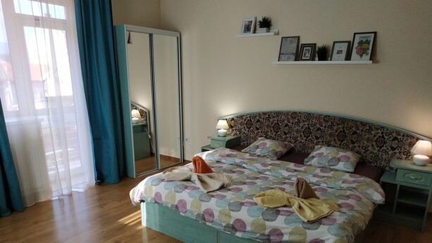 A bedroom with a bed, bedside tables, a mirror, and a wardrobe. - VIP Apartments in the Centre (Mukachevo)