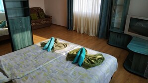 A hotel room with a bed, a wardrobe, a television, and a sofa.