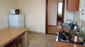 A compact kitchen with a microwave, refrigerator, sink, and stove. - VIP Apartments in the Centre (Mukachevo)