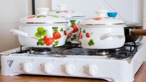 Three white pots with strawberry designs on a white gas stove. - Best Apartments on Beregovskaya (Mukachevo)