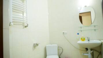 Une salle de bain avec des toilettes, un lavabo et un miroir.