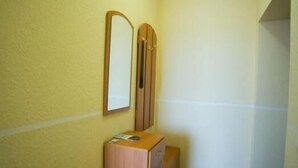 A narrow hallway with yellow walls, a wooden cabinet, and a mirror on the wall. - Best Apartments on Beregovskaya (Mukachevo)
