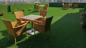 Une terrasse sur le toit, aménagée avec des meubles en osier et offrant une vue sur le panorama urbain.