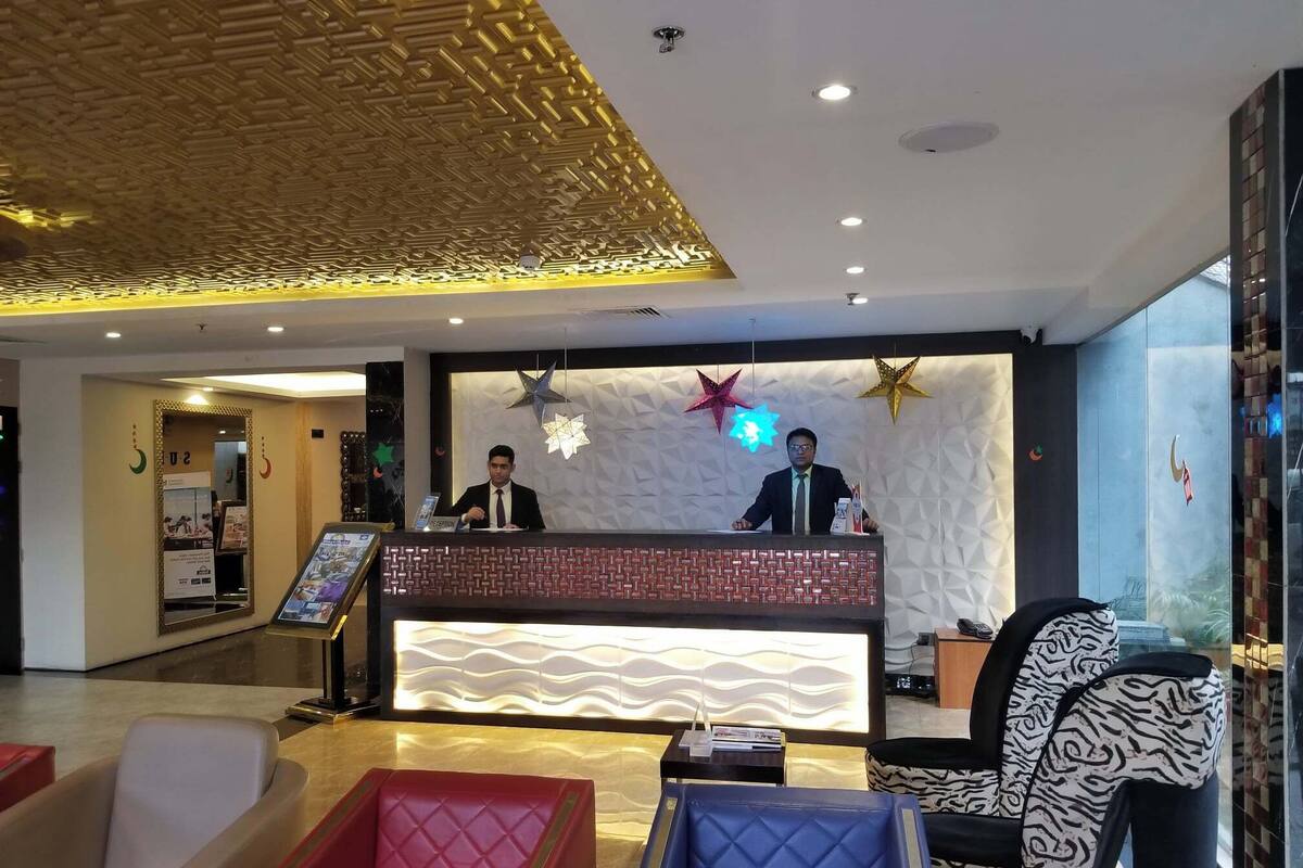 A hotel reception area with a modern design, including a reception desk, seating area, and decorative elements.
