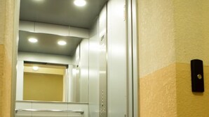 An elevator with a "WELCOME" mat at the entrance.