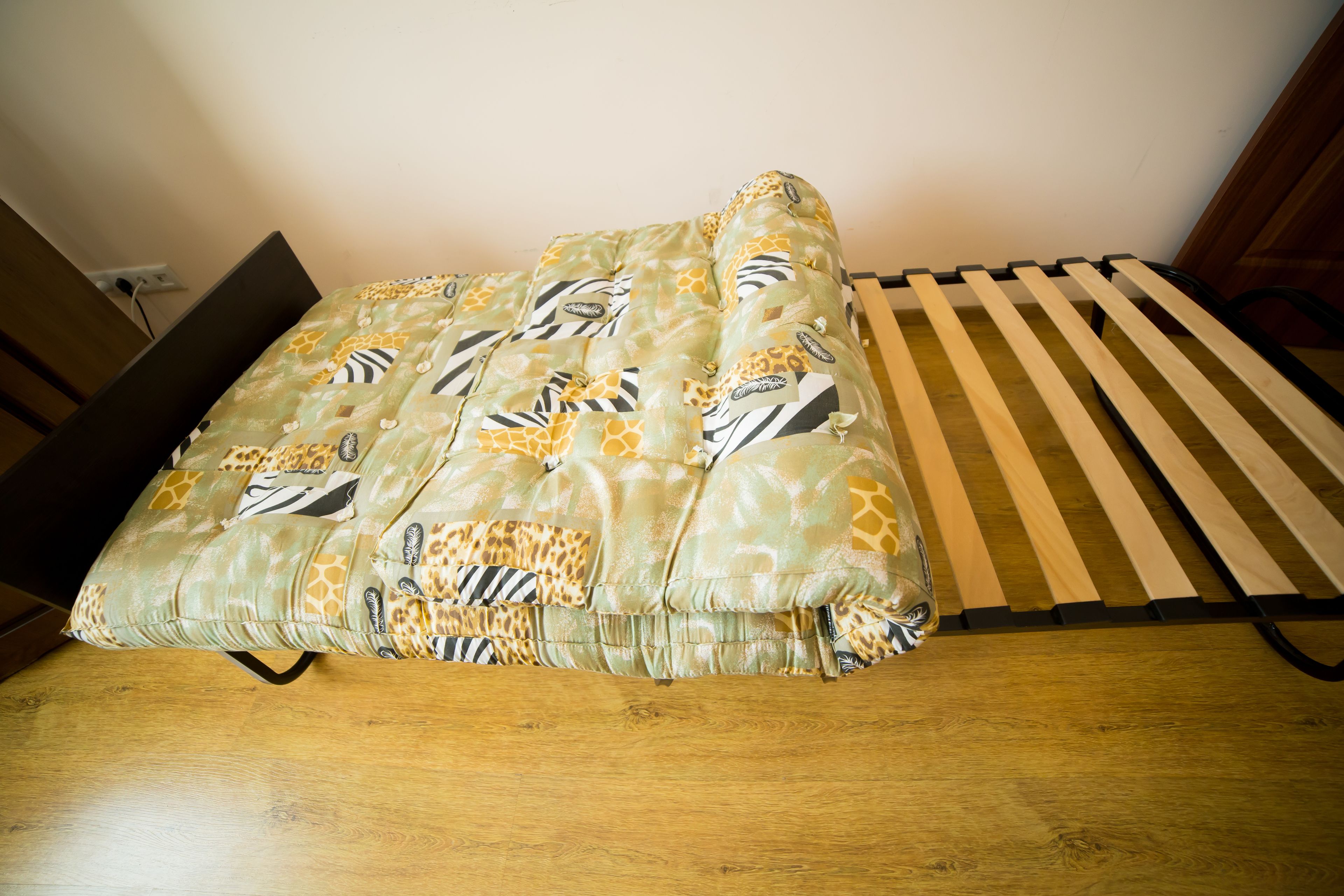 Una cama con una colcha estampada y un cabecero de madera.