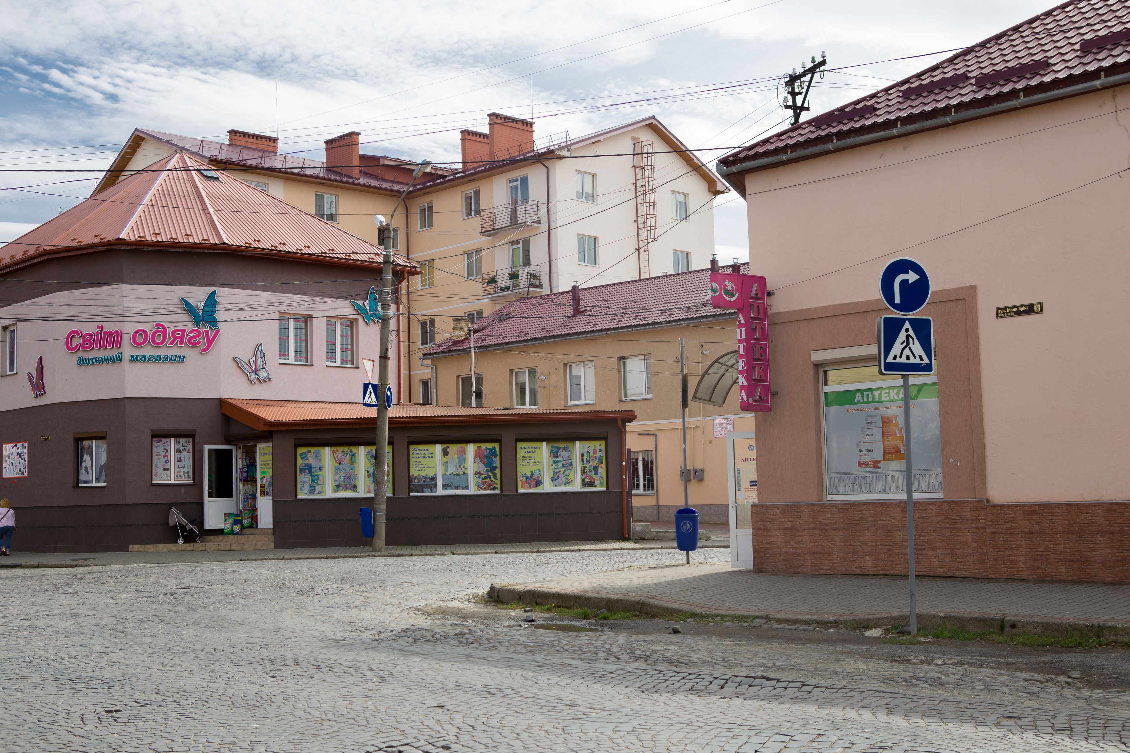 A building with a sign that reads "СВИМ ОДЕЖУ" and another sign with "ANTEKA".