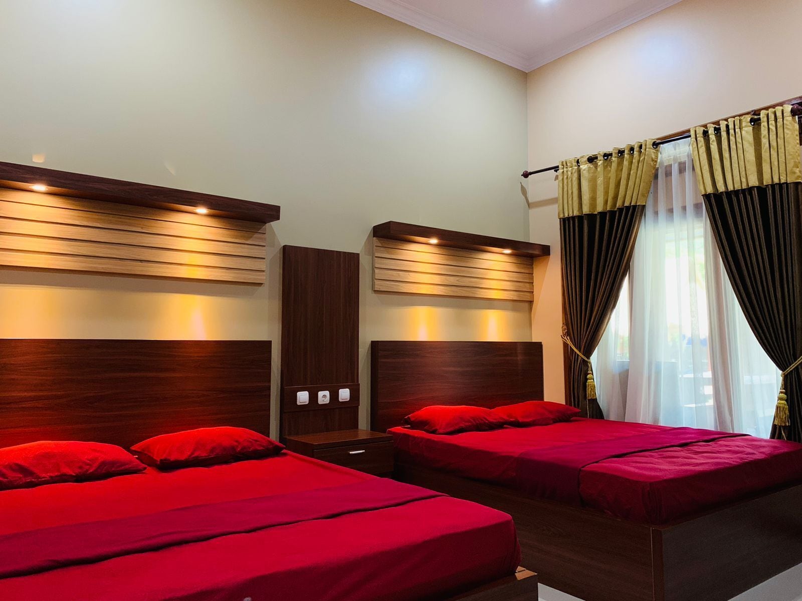 Une chambre d’hôtel avec deux lits, des têtes de lit en bois et une fenêtre avec des rideaux.