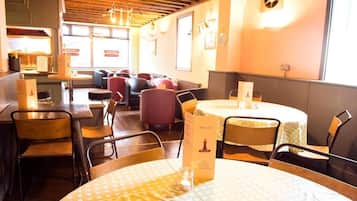 A restaurant with round tables, chairs, and a menu stand.