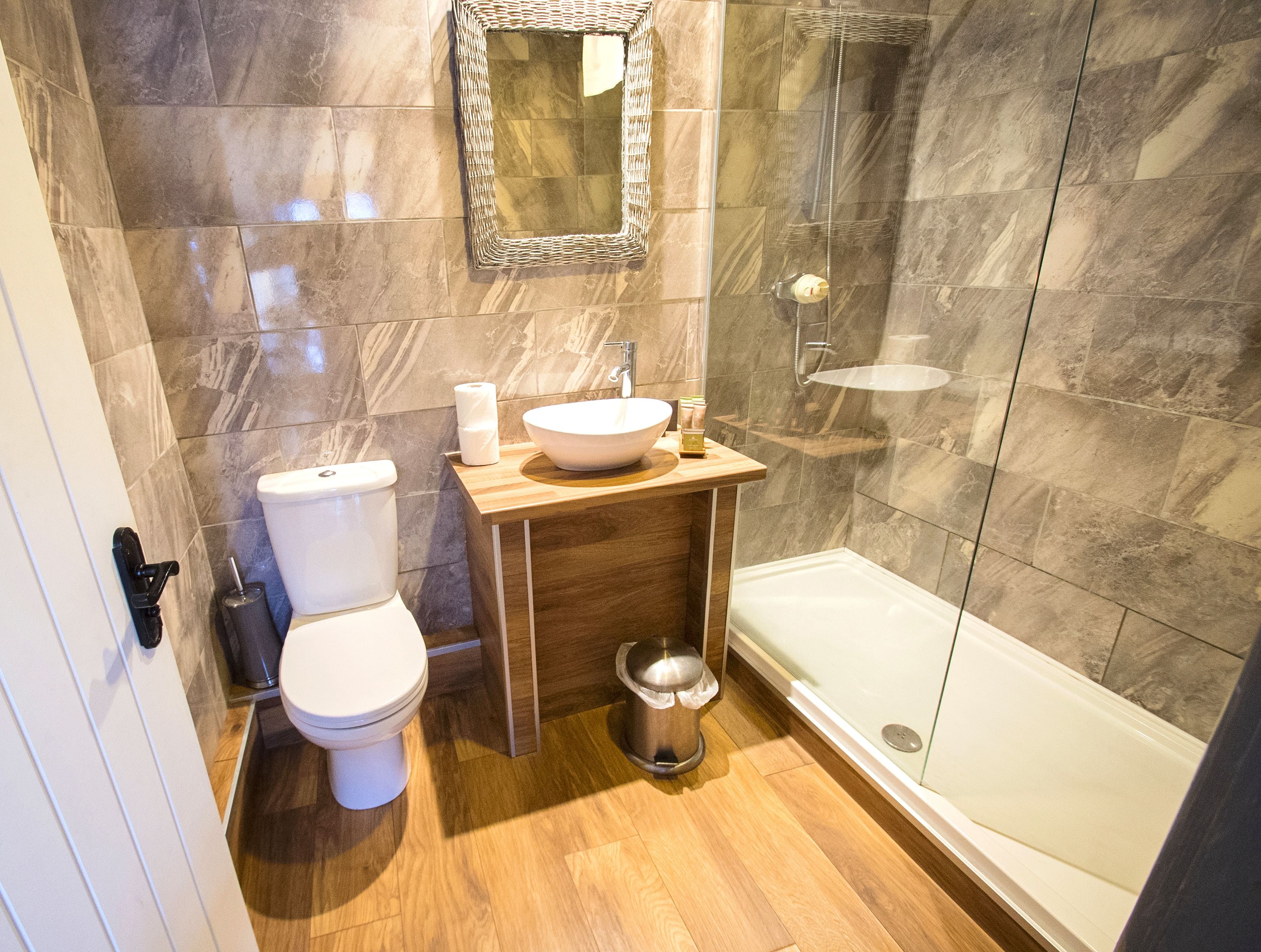 A modern bathroom with a toilet, sink, and shower.