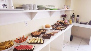 Une table de buffet proposant une variété de plats et de boissons.