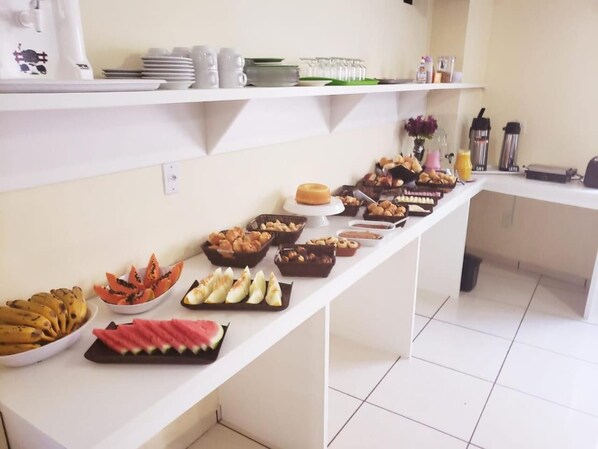 A buffet table with various food items and beverages.