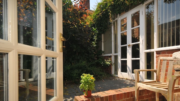 A brick wall with a wooden bench and a potted plant. - Edderton Hall Country House (Welshpool)