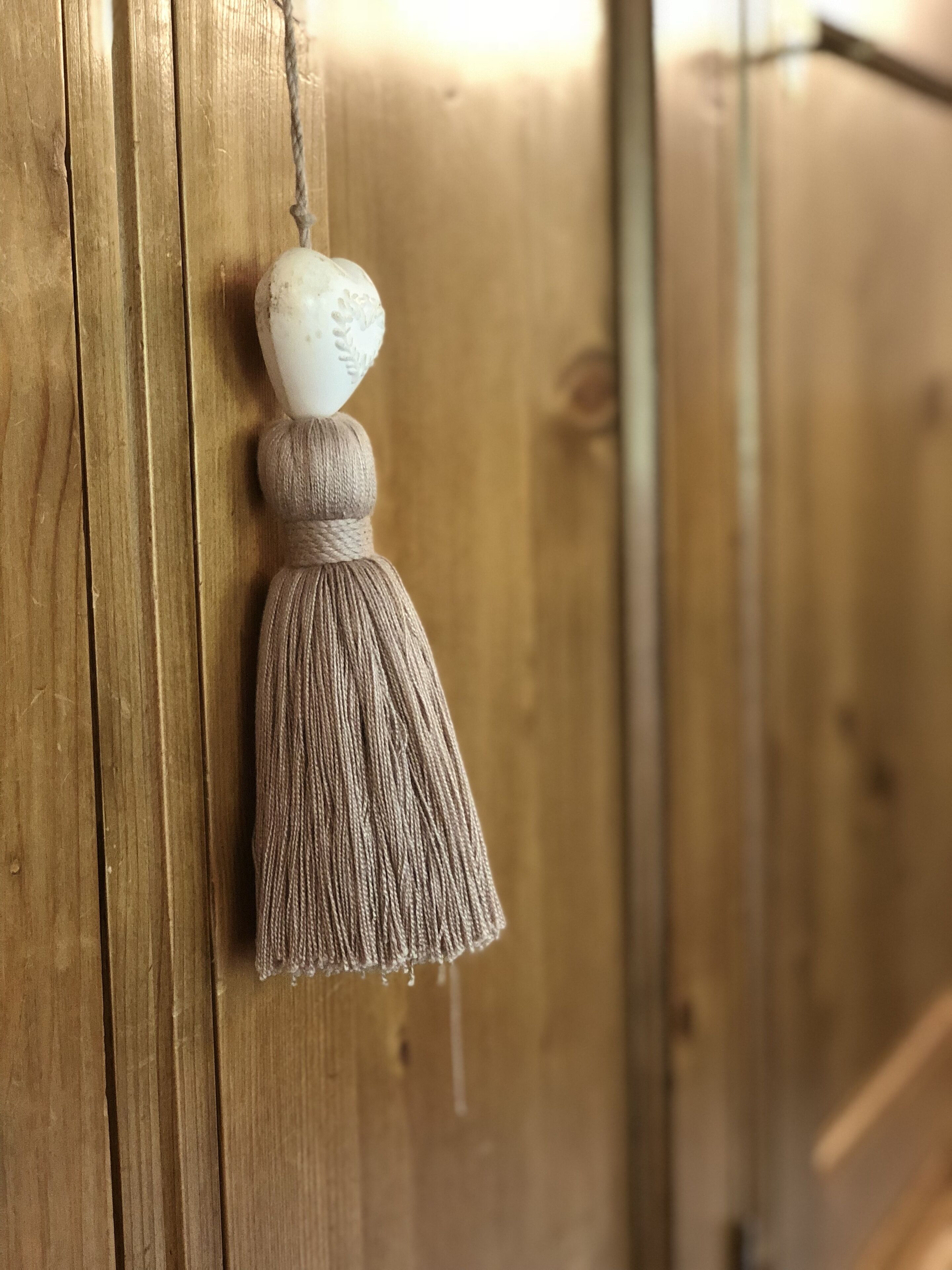 Una puerta de madera con un adorno blanco colgando.